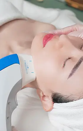 Beautiful woman in white having the ultraformer procedure by an aethetician